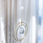 Attrape soleil cristal, à coté d'une fenêtre avec des arcs en ciel de lumière, DENADDA