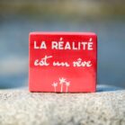Pancarte décorative en bois couleur rouge avec message la réalité est un rêve. Fait main par DENADDA