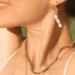 Boucle d'oreille pendante Aura un bijou porté par une femme. Fait à la main par DENADDA.