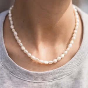 Collier perles d'eau douce blanche autour du cou. Un bijou fait main par Elma de DENADDA.