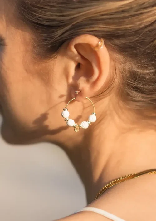 Boucle d'oreille créole pierre de lave blanche - Etna Boucle d'oreille créole pierre de lave blanche avec pendentif en forme de goute d'eau. Un magnifique bijou fait main par DENADDA.