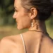 Une femme qui porte une boucle d'oreille pendante en perle d'eau douce. Aura un bijou fait main par DENADDA.