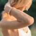 Une femme porte un bracelet en perles d'eau douce. Ondine est un bijou fait main par DENADDA.