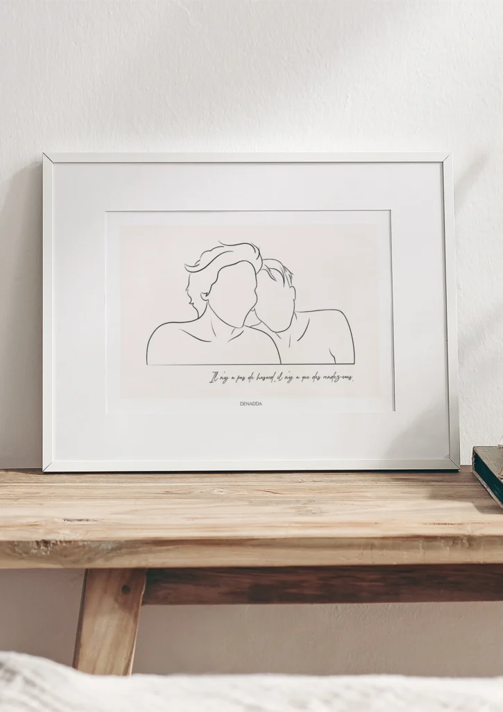Cadre personnalisé couple dessin minimaliste avec citation sur un fond uni posé sur une table en bois. Dessin style line art réalisé d'un seul trait par Denadda. Idéal pour une décoration intérieur minimaliste. Cadeau de couple original et unique.