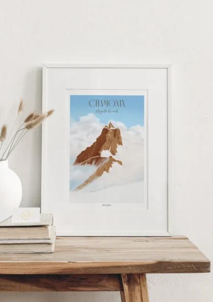 Cadre Chamonix l'Aiguille du Midi, posé sur une étagère en bois clair, montrant le sommet émergent au-dessus des nuages. Une création de Denadda pour la décoration d'un chalet de montagne.