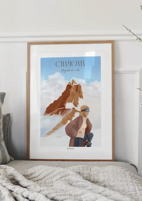 Tableau Chamonix "L'aiguille du Midi" Tableau Chamonix l'Aiguille du Midi posée sur un lit, montrant le sommet émergent au-dessus des nuages avec une skieuse. Une création de Denadda.