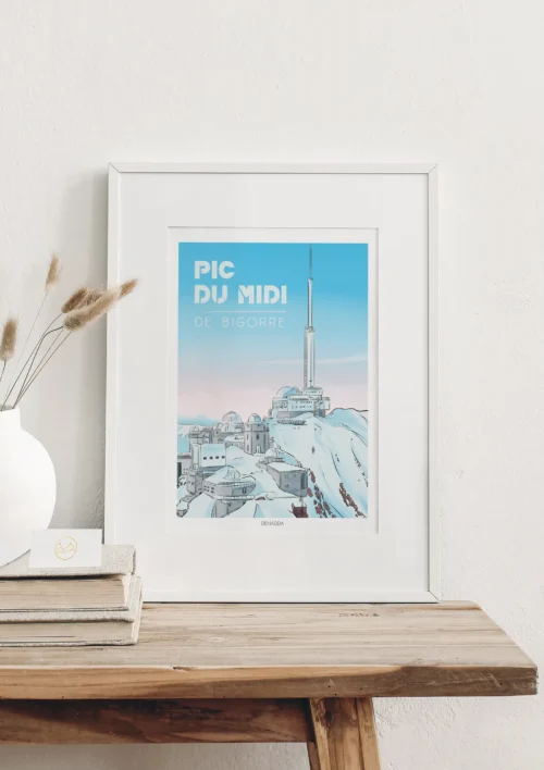 Cadre Pic du Midi de Bigorre "Les Pyrénées" Cadre du Pic du Midi de Bigorre, les Pyrénées en style BD illustré par Denadda, présentée sur un mur clair pour la décoration intérieure d'un chalet de montagne.