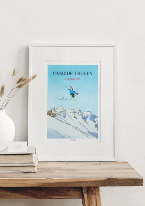 Cadre Ski Freestyle "X-Up" Cadre ski freestyle personnalisé de Candide Thovex skieur français réalisant une figure X-Up au-dessus d’une montagne enneigée, illustration de Denadda dans un style bande dessinée.