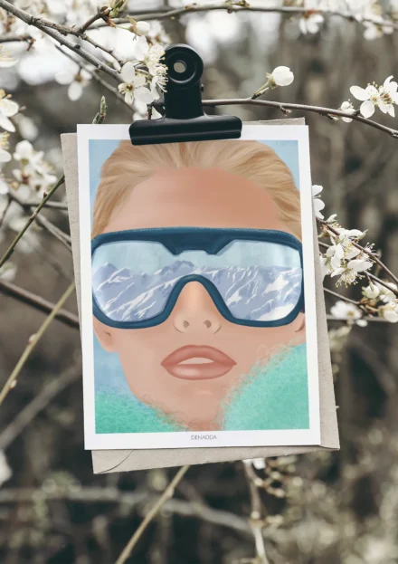 Poster ski portrait d'un visage féminin avec lunettes reflétant les sommets enneigés, illustration moderne de Denadda pour une déco montagne.