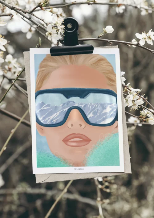 Poster Ski Portrait “Reflet de Montagne” Poster ski portrait d'un visage féminin avec lunettes reflétant les sommets enneigés, illustration moderne de Denadda pour une déco montagne.